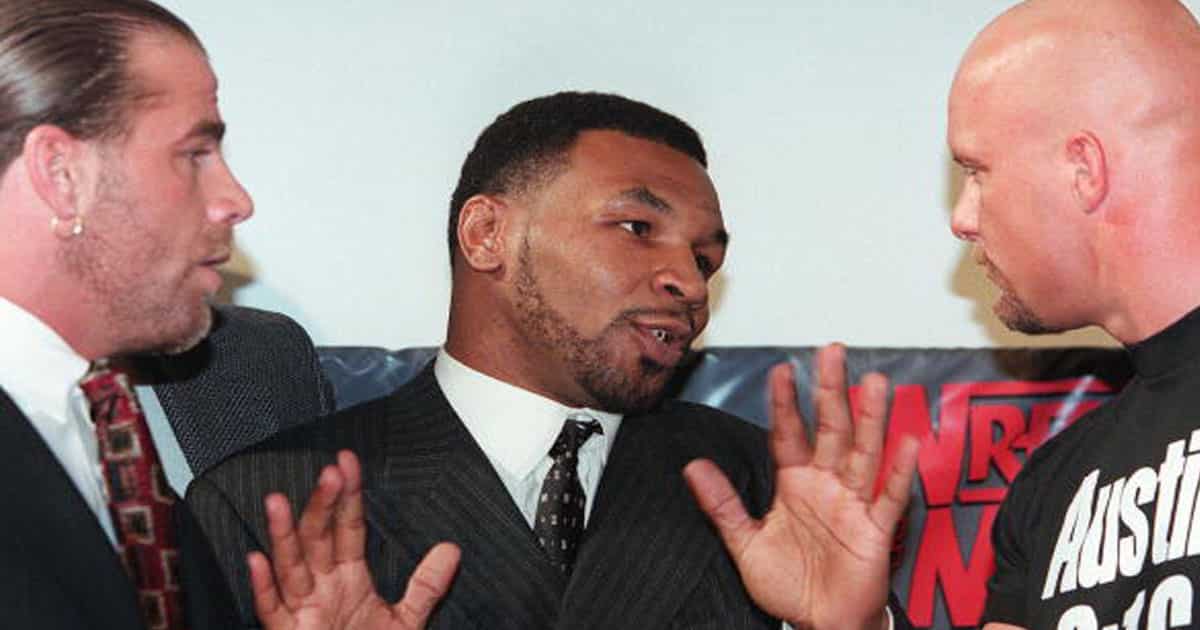 Former world heavyweight boxing champion Mike Tyson (C) acts as a referee between World Wrestling Federation wrestlers Shawn Michaels (L) and Steve Austin (R) at a press conference